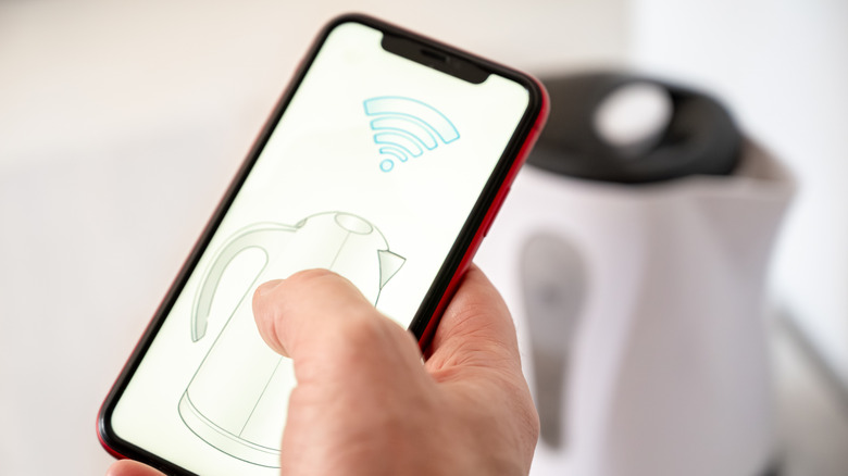A person connecting their electric kettle to their phone