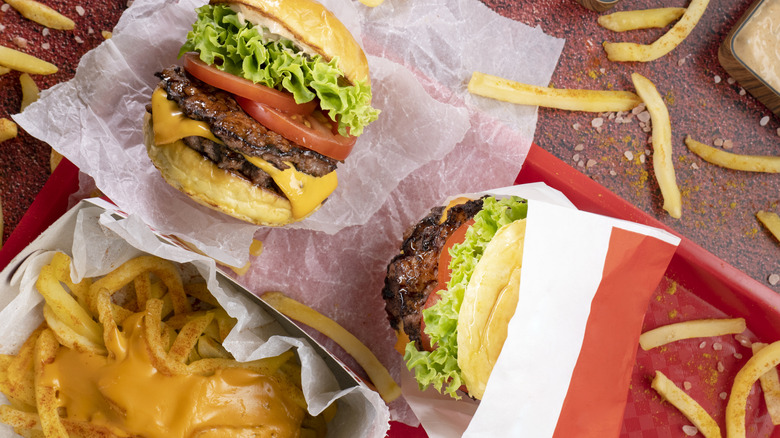 A close-up of fast food cheeseburgers and fries.