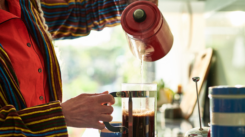 Man in a striped suit prepares black coffee