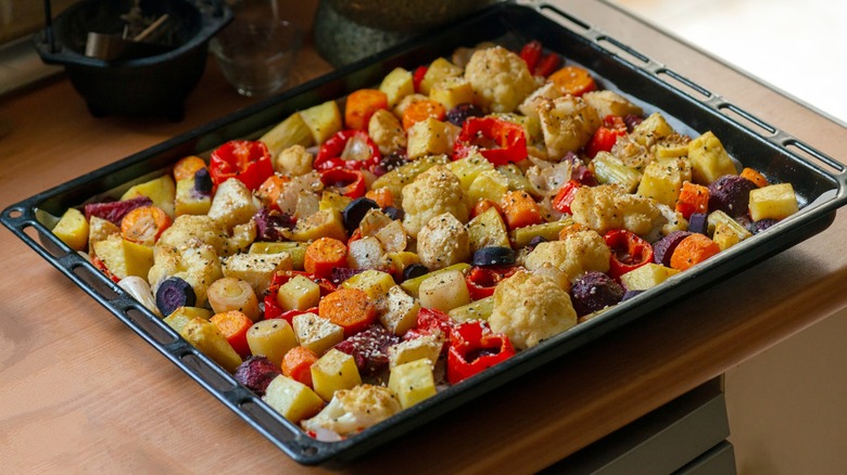 Roasted veggies in a sheet pan on a kitchen counter