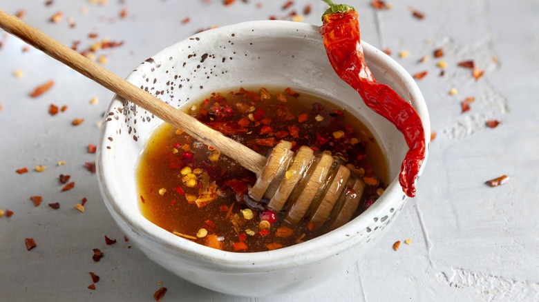Honey mixed with hot peppers in a white bowl