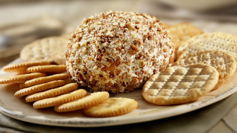 A SugarBee apple cheeseball on a plate with crackers