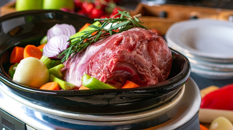 Raw pork with vegetables in a slow cooker