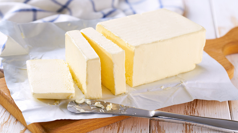 Butter on paper wrapper sliced with knife