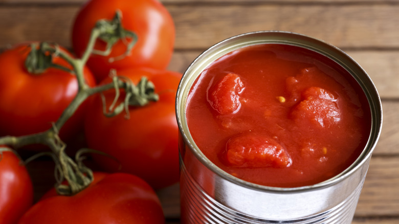 fresh tomatoes next to can of tomatoes