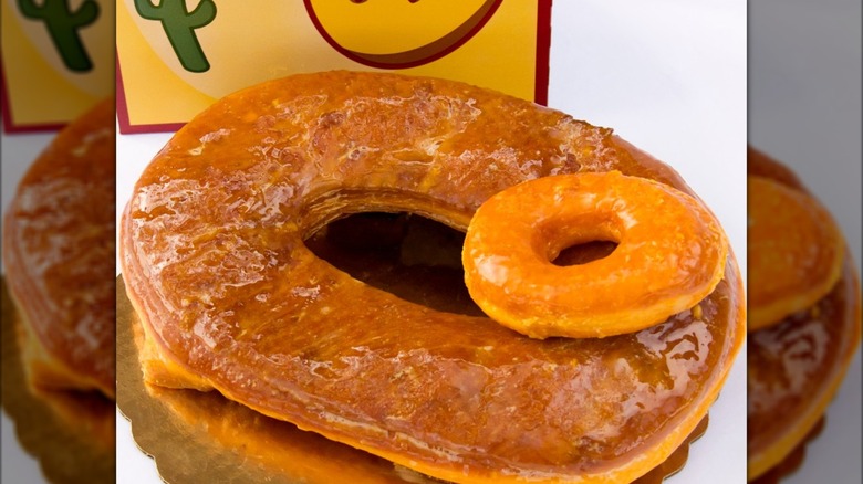 A large donut with a smaller one resting on top.