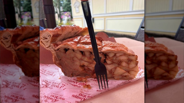 A fork next to a large apple pie slice for scale