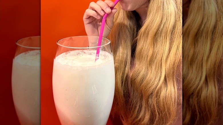 Woman sipping a giant milkshake