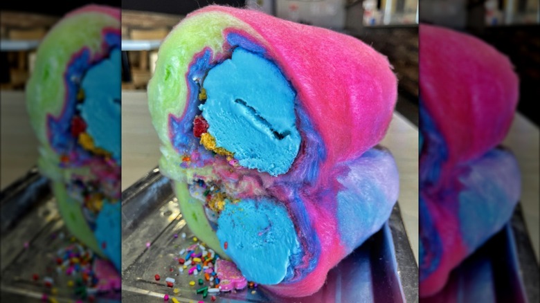 Colorful cotton candy wrapped around blue ice cream like a burrito.