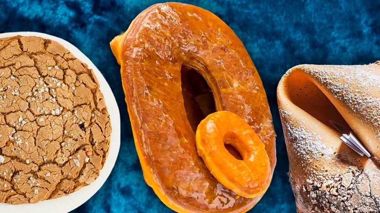 A cookie, a donut, and a fortune cookie lying on a blue background.