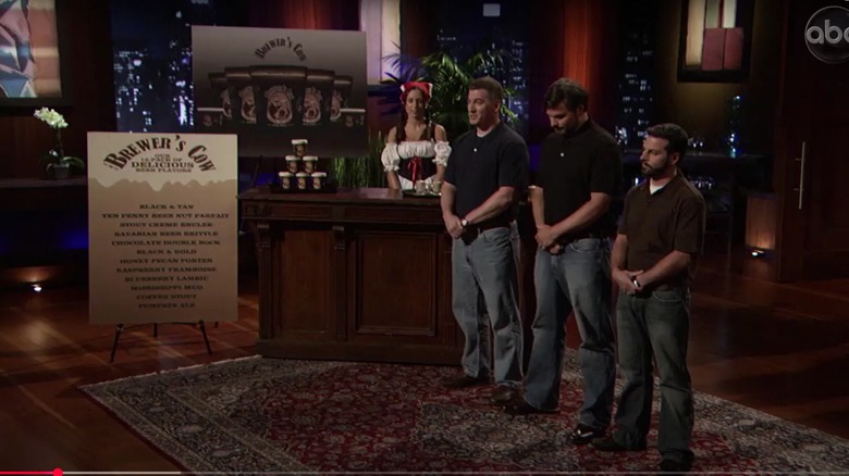 Steve Albert, Larry Blackwell, Jason Conroy, and a woman dressed like a beer maiden next to the display for Brewer's Cow Ice Cream on Shark Tank
