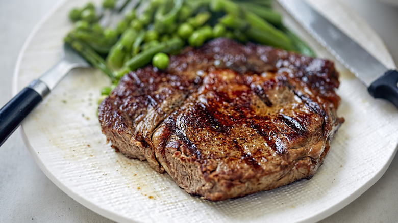 Grilled steak with vegetables on a white plate