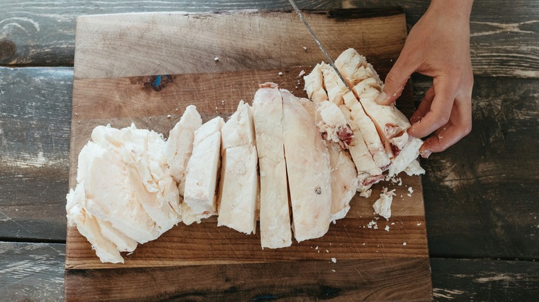 A chef cuts beef tallow on a wooden board