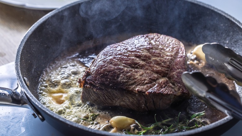 Steak searing in a cast iron skillet.