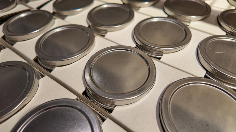 A birdseye view of several lines of mason jar lids.