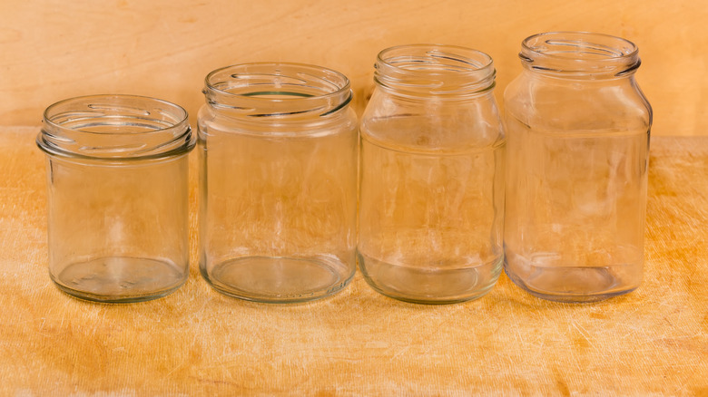 Four different sized mason jars lined up from smallest to largest left to right.
