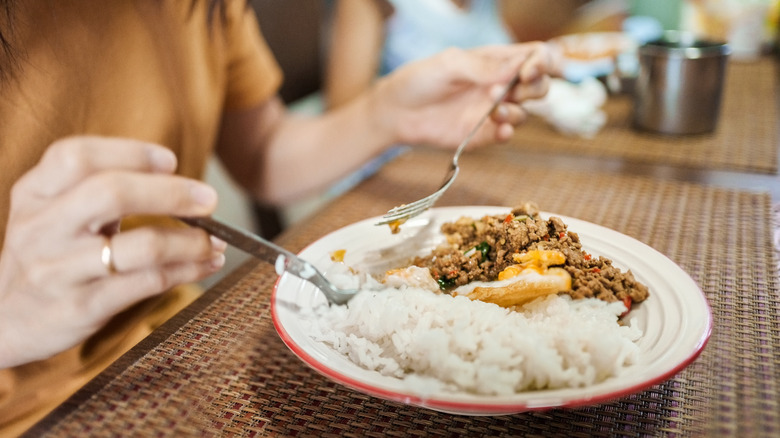 Woman eating rice off plate