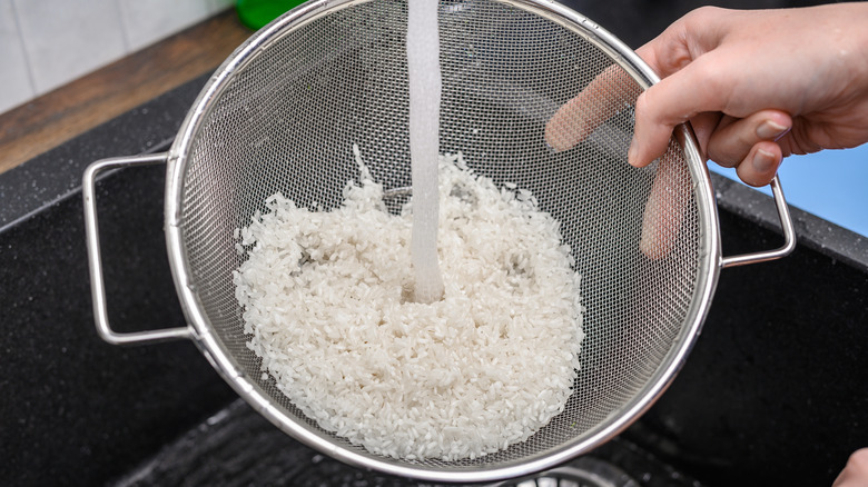 Woman rinsing rice in colander
