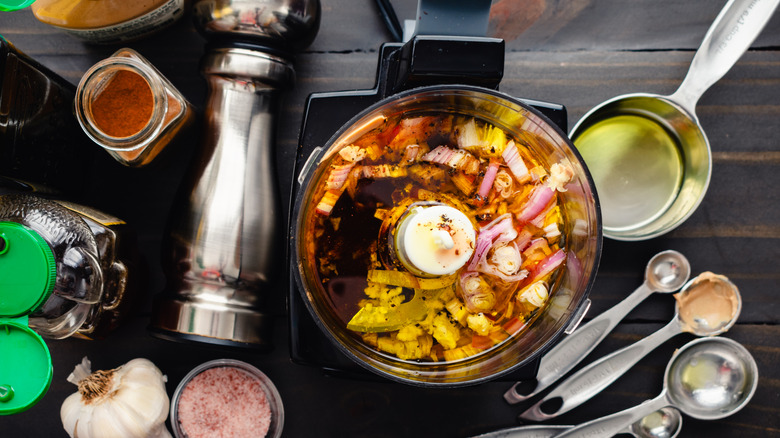 Small food processor filled with ingredients in a kitchen