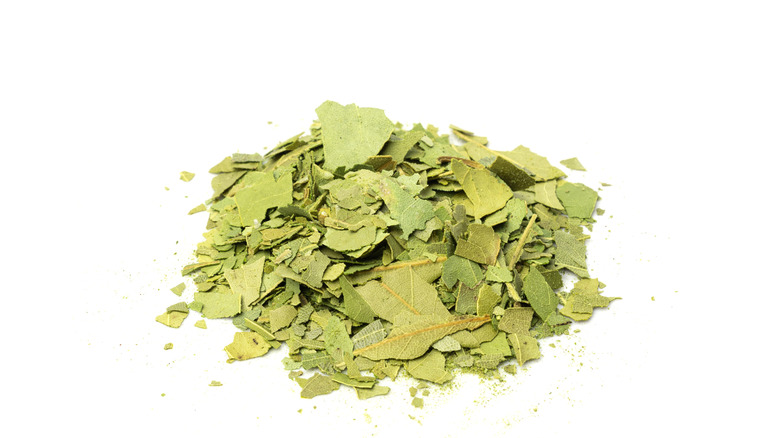 A pile of broken bay leaves on a white background