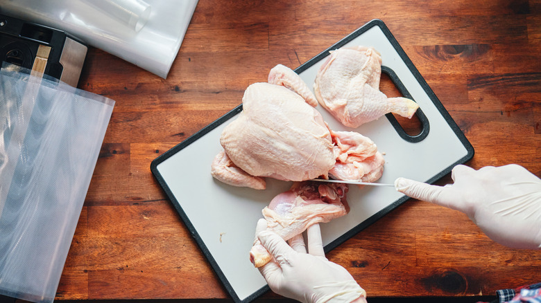 Food Safety - Cutting Chicken on Plastic Cutting Board with Food Gloves