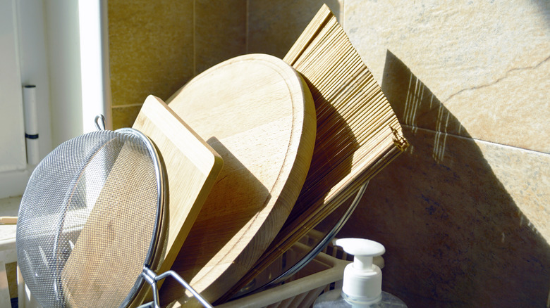 wooden boards, sieve and lids hand washed after cooking, close-up.