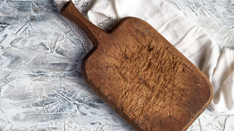 Old wooden cutting board with white fabric