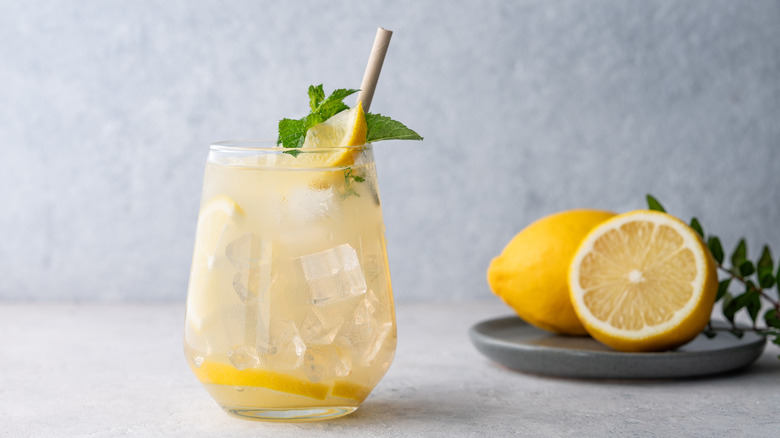 A glass of homemade lemonade with fresh herbs