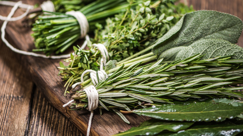 Bundles of fresh herbs on a wood board