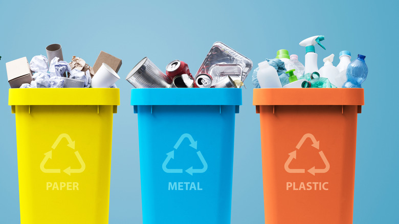 Three bins filled with types of recycling in colors of yellow, blue, and red