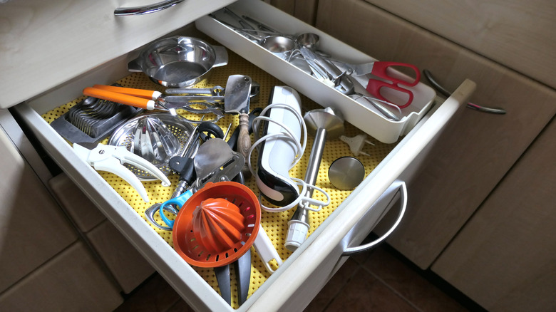open drawer with unorganized kitchen tools