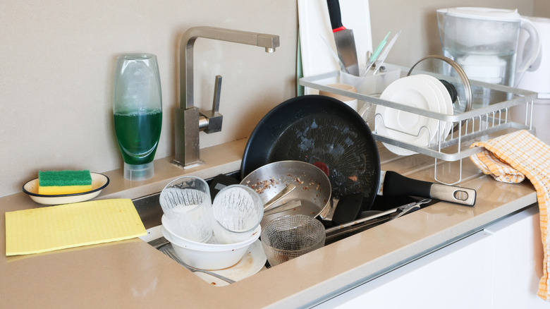 Dirty dishes piled up in the sink
