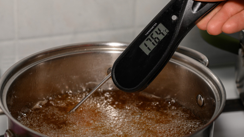 Taking the temperature of frying oil in a pot