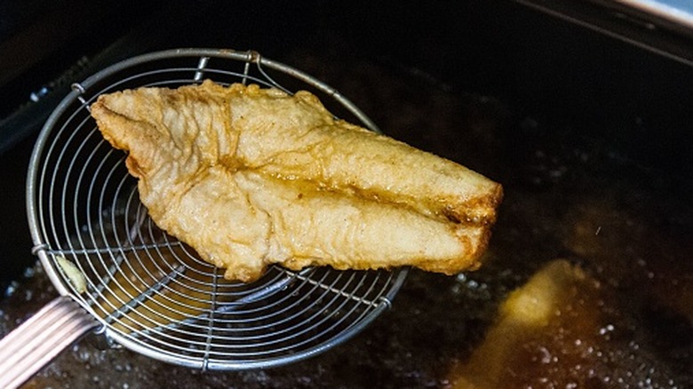 A close-up of battered fish deep-fried in oil