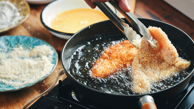 Frying crispy chicken in a pan