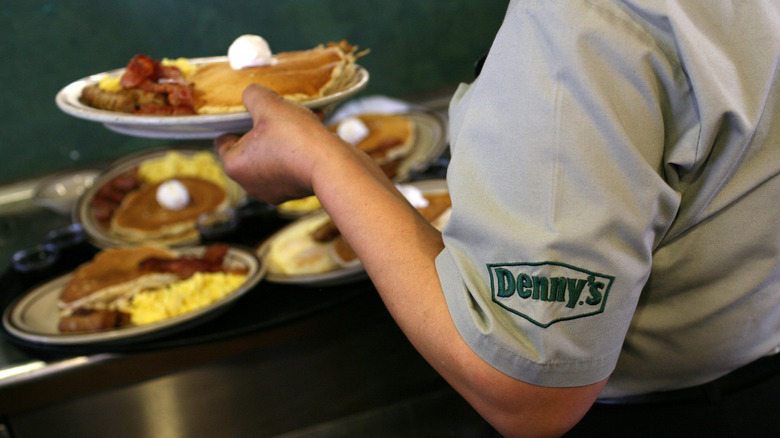 Server holding breakfast platter at Denny's.