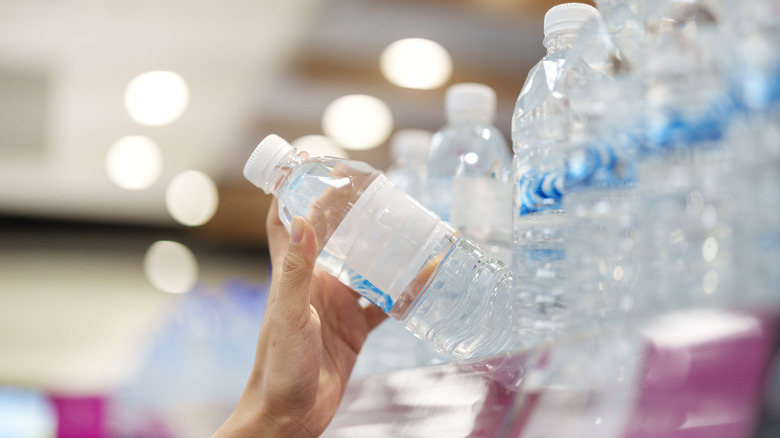 hand grabbing water from shelf