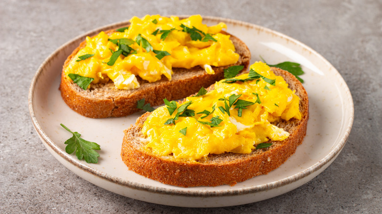 Scrambled eggs on toast with fresh parsley