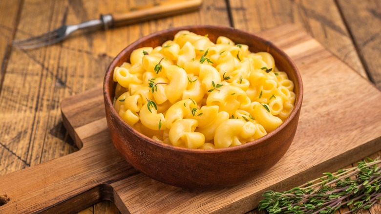 Mac and cheese in rustic bowl on wood board
