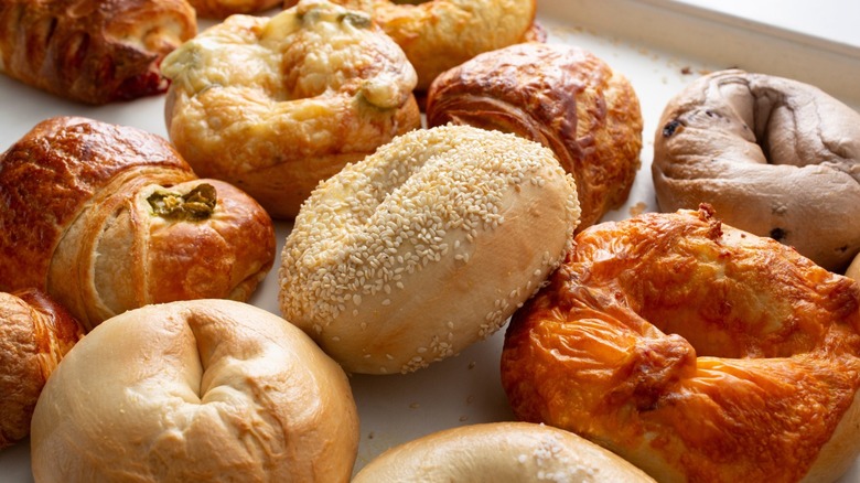 Assorted types of bagels and pastry arranged on a tray