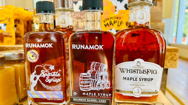 Three bottles of different brands of pure maple syrup in a store