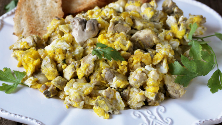 A large portion of scrambled eggs and cow brains on a white plate
