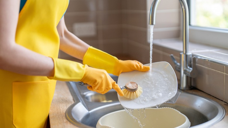 Someone rinsing dishes