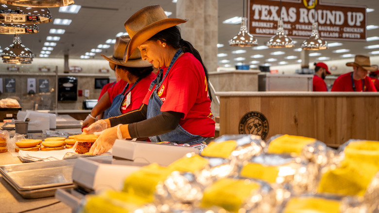 Workers make sandwiches at Buc-ee's barbecue station inside the store