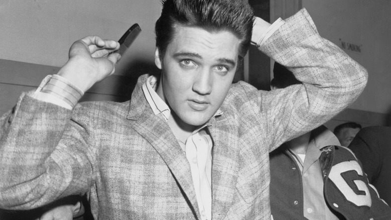 Elvis Presley holding comb with arms up