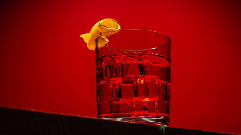 A Negroni cocktail on a dark red background