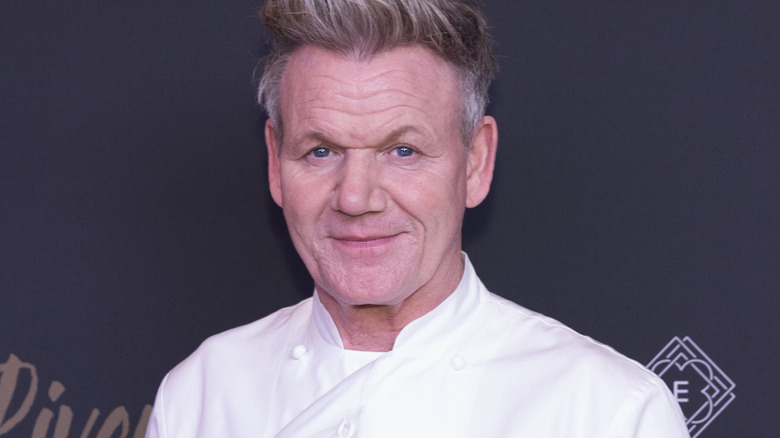 Gordon Ramsay smiles in a chef's jacket at an event