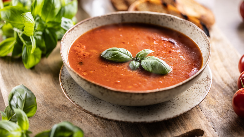 Bowl of tomato soup garnished with basil