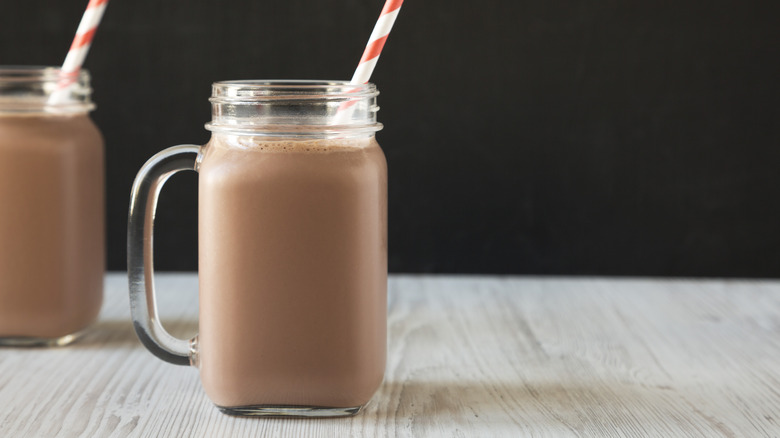Chocolate milk in glass jar with straw