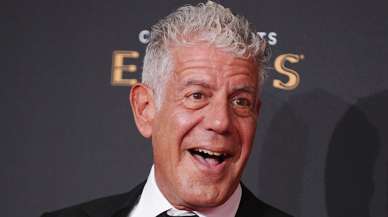 Anthony Bourdain smiles in black tie and jacket